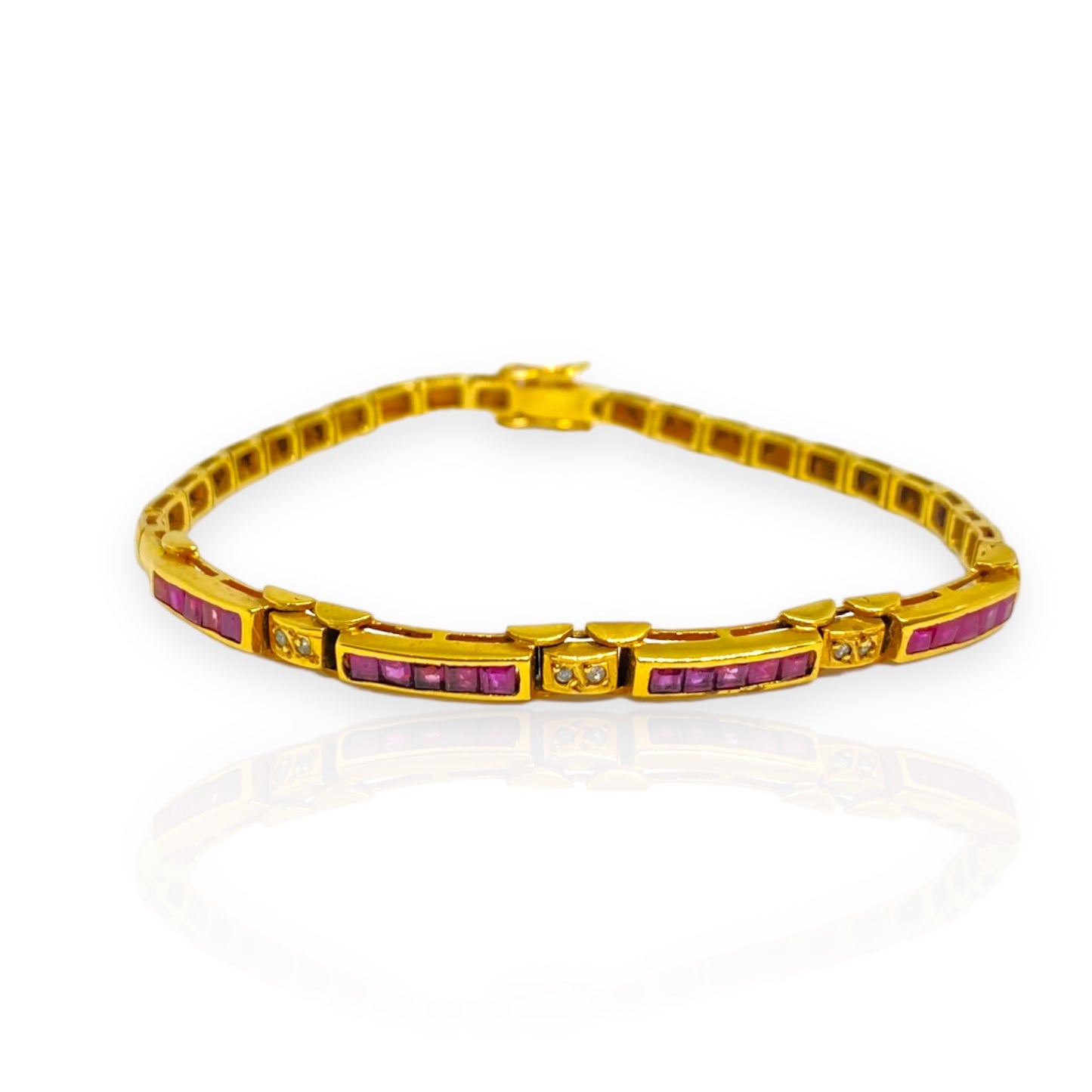 Pulsera semi rígida de oro de 18kt con 20 rubíes talla princesa y 6 diamantes talla brillante de 0.01ct cada uno. Esta preciosa pulsera vintage tiene un cierre cajón y doble cierre de seguridad. Pesa 12,33g con las piedras incluídas y mide 19cm. Compra joyas al mejor precio en Barcelona, compro oro barcelona