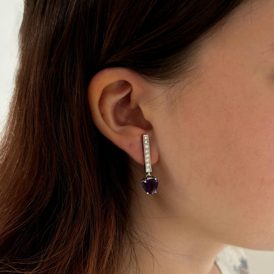 Pendientes colgante realizados en oro blanco de 18kt con engaste de amatista talla corazón y barra de 8 diamantes talla brillante en cada pendiente. Cierre de presión.Joyas de novia, segunda mano, restauración y creación de joyas, compro oro Barcelona. Joyeria Ian'Or dónde comprar y vender oro y joyas al mejor precio en Barcelona