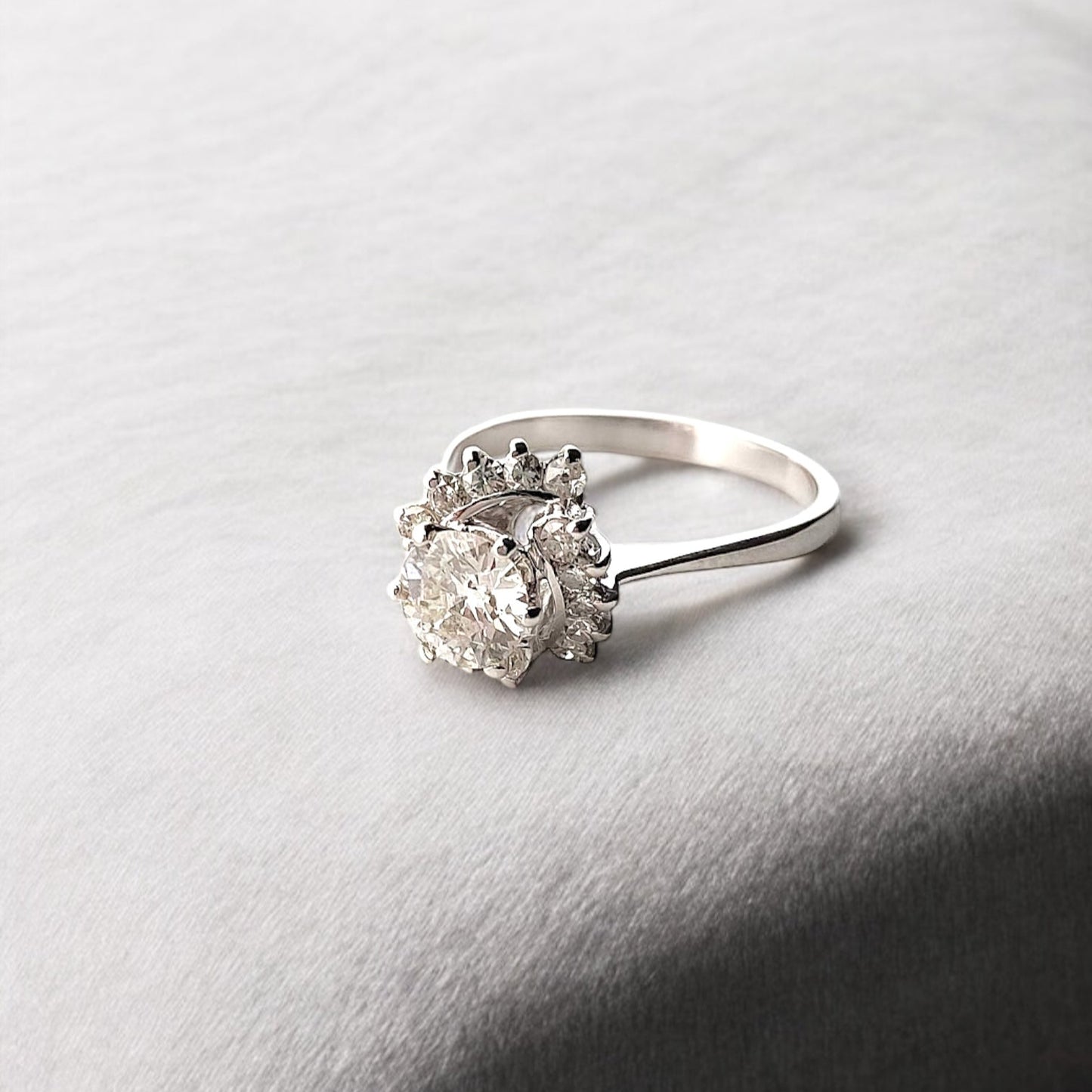 Comprar sortija realizada en Oro blanco de 18kt con rosetón de diamantes. Diamante central talla brillante de 6,47mm y rosetón de 12 brillantes de 0,04ct cada uno