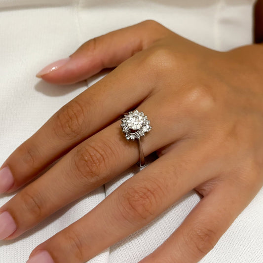 Comprar sortija realizada en Oro blanco de 18kt con rosetón de diamantes. Diamante central talla brillante de 6,47mm y rosetón de 12 brillantes de 0,04ct cada uno