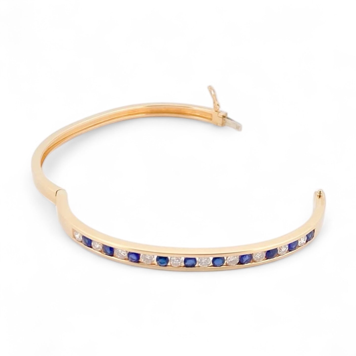 Pulsera esclava de Oro amarillo de 18kt con zafiros y diamantes. Esta preciosa pulsera rígida dispone de cierre de cajón. Joyas de segunda mano en Barcelona, compro oro y joyas al mejor precio. Joyería Compro Oro Barcelona, el mejor precio por tu oro y por joyas de segunda mano.