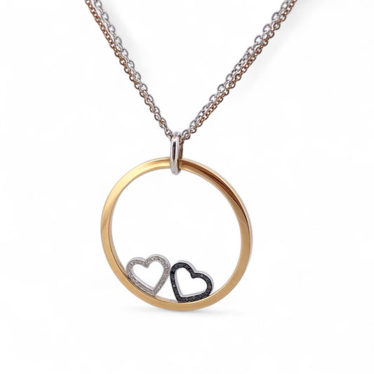 Collar de la firma Pesavento en oro blanco y amarillo de 18kt con circunferencia y dos corazones en su interior. Collar con diamantes negros y blancos.
