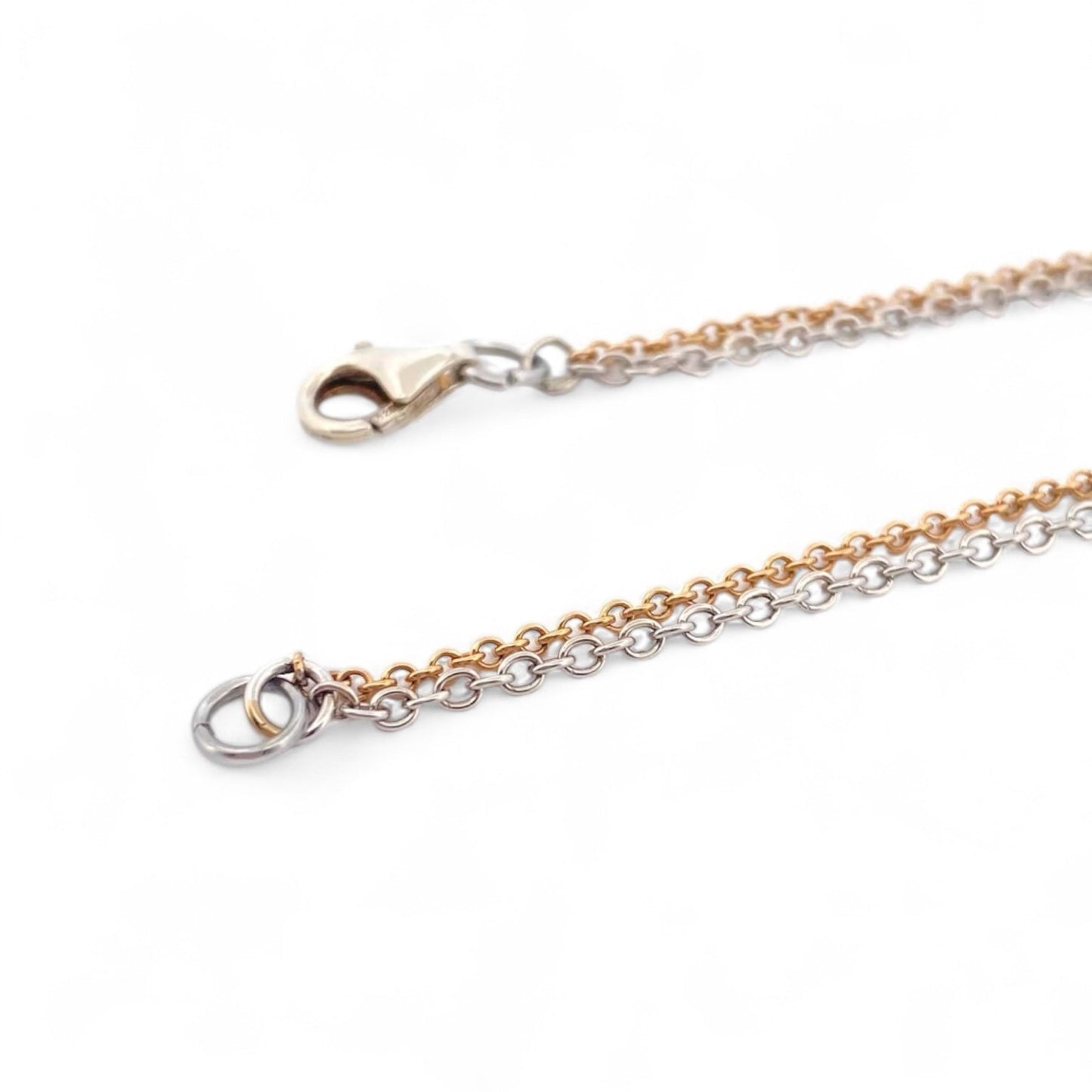 Collar de la firma Pesavento en oro blanco y amarillo de 18kt con circunferencia y dos corazones en su interior. Collar con diamantes negros y blancos.
