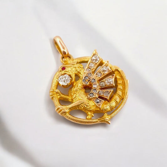 Exclusivo colgante antiguo de oro amarillo de 18kt destaca por su diseño artesanal en forma de dragón, símbolo de fuerza y protección. Adornado con un diamante central de 3mm y ojo de rubí y 18 diamantes talla antigua en sus alas. Una pieza vintage y única para los amantes de este ser mitológico.