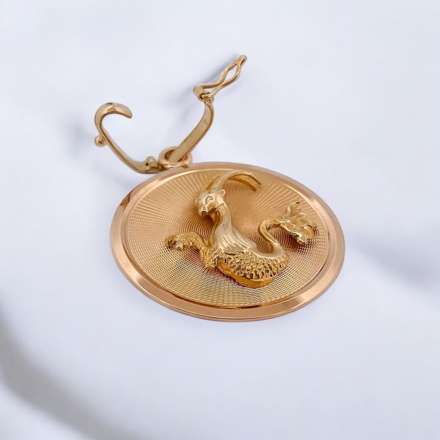 Colgante medalla con el signo del Zodiaco de Capricornio realizada de oro amarillo de 18kt . La medalla hace 134mm de diámetro y la balía dispone de cierre de seguridad y mide de 12mm