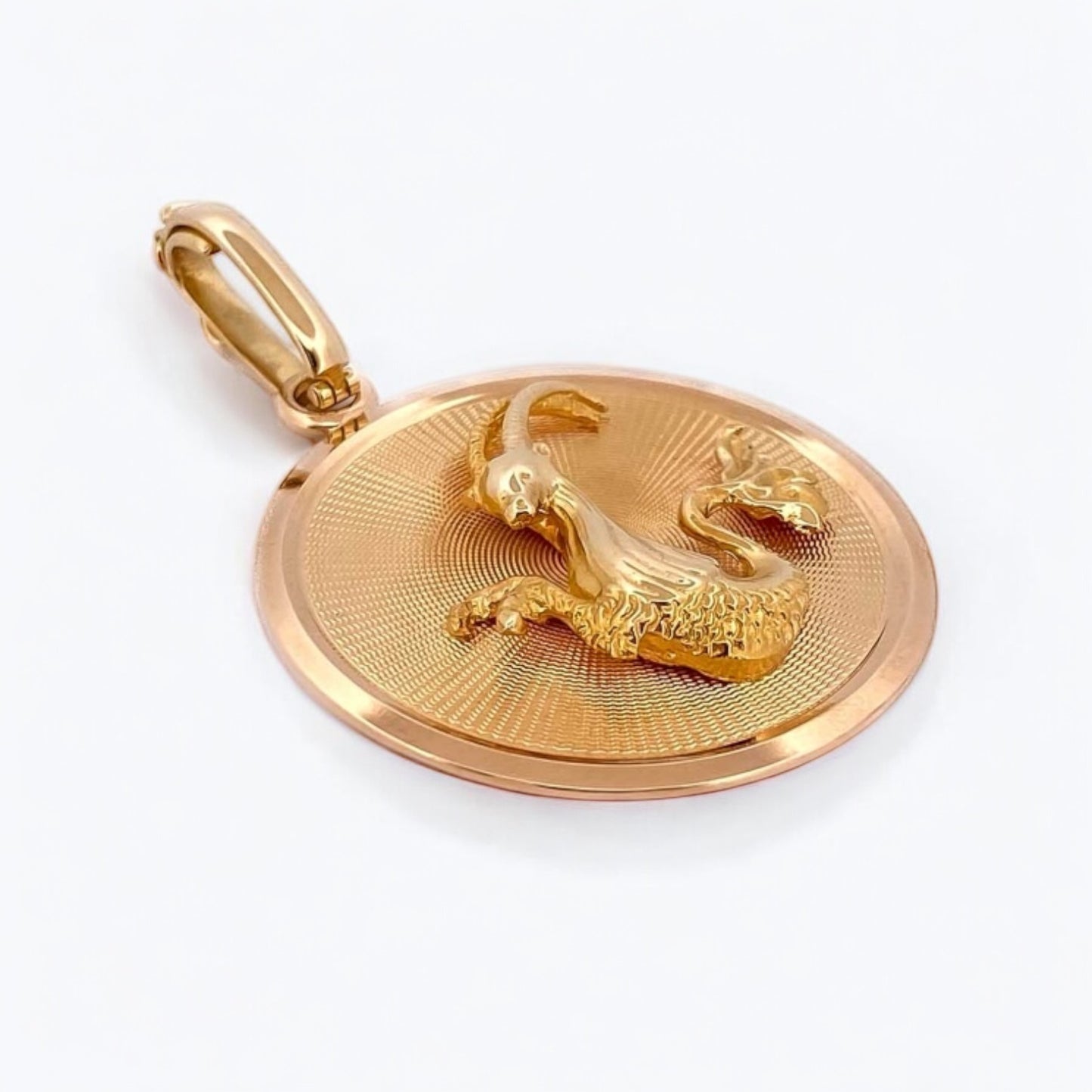 Colgante medalla con el signo del Zodiaco de Capricornio realizada de oro amarillo de 18kt . La medalla hace 134mm de diámetro y la balía dispone de cierre de seguridad y mide de 12mm
