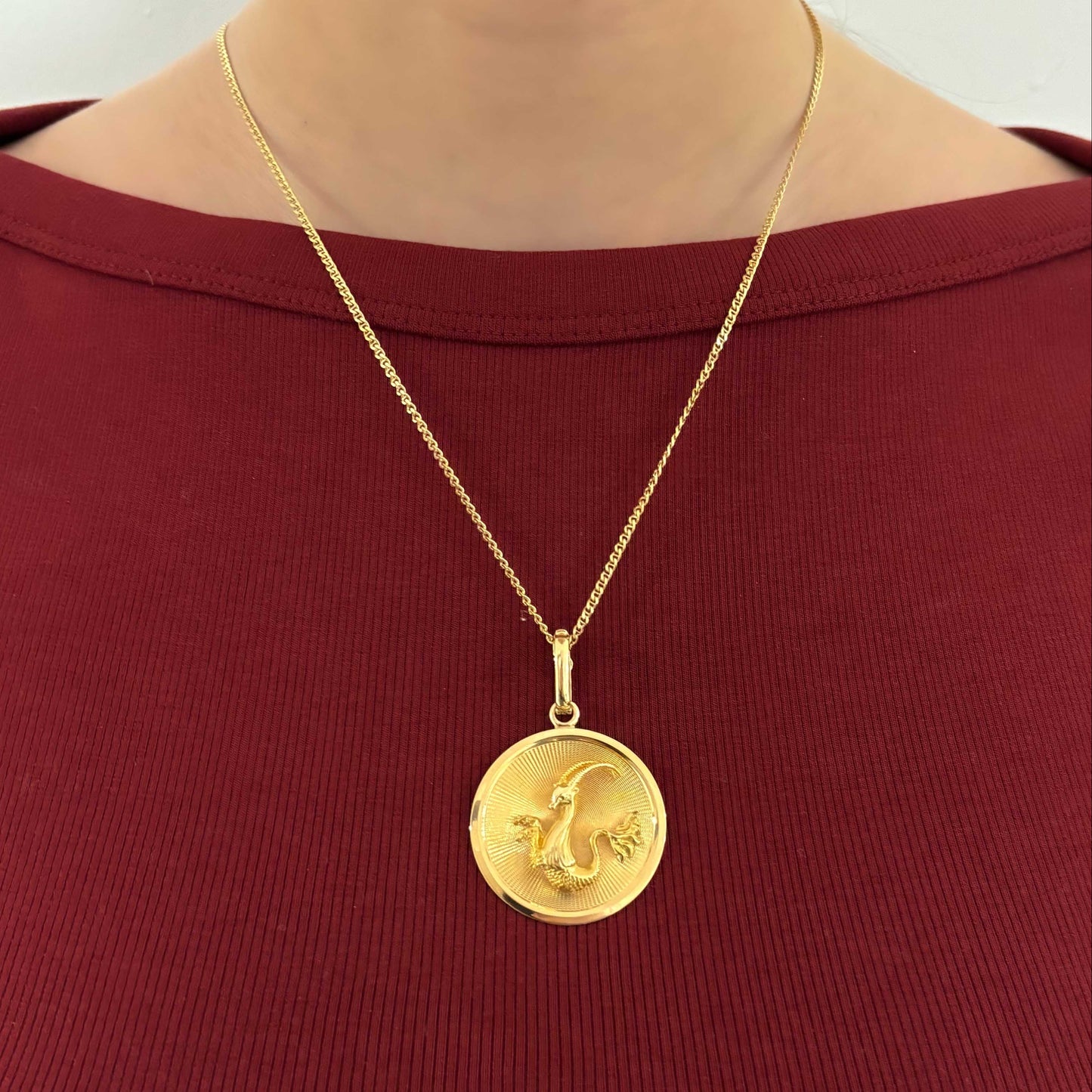 Colgante medalla con el signo del Zodiaco de Capricornio realizada de oro amarillo de 18kt . La medalla hace 134mm de diámetro y la balía dispone de cierre de seguridad y mide de 12mm
