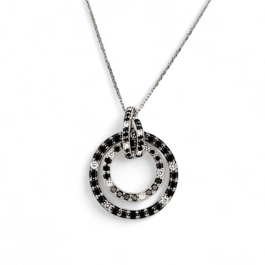 Comprar colgante en oro blanco de 18kt en forma de círculos con diamantes negros y blancos. Joyas segunda mano. Joyería Ian'Or.