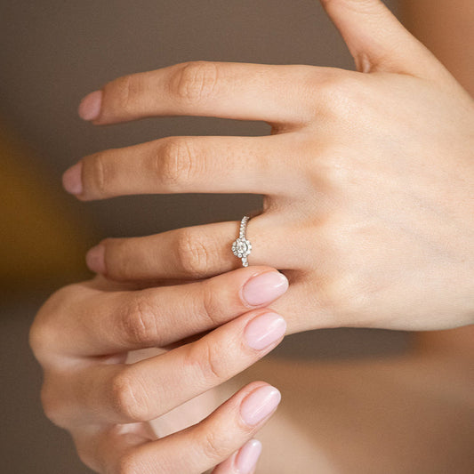 Comprar sortija de la firma Suarez realizada en oro blanco de 18kt con rosetón de diamantes alrededor de un diamante central más grande. Joyas de Ian'Or.