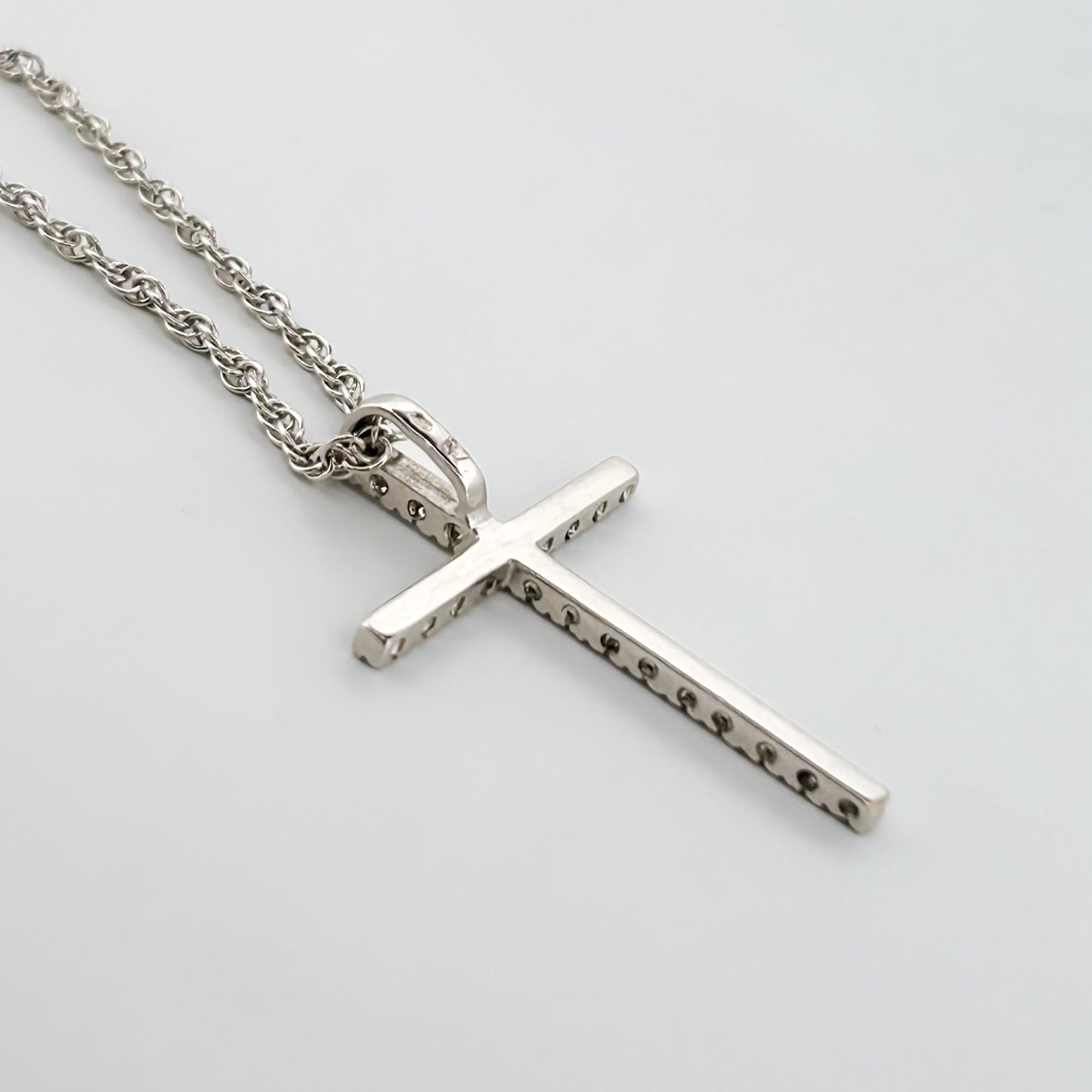 Comprar colgante en oro blanco de 18kt en forma de cruz con un total de 22 diamantes talla brillante. Cierre tipo mosquetón. Joyería Compro Oro Barcelona.