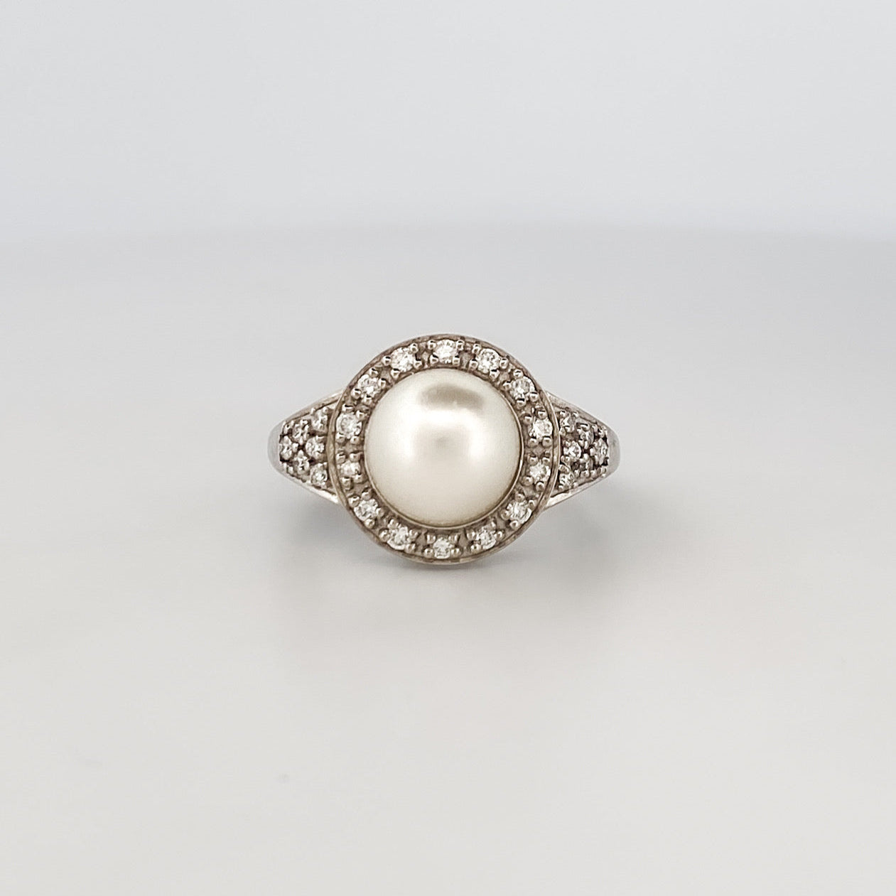 Comprar anillo de oro blanco de 18kt con perla central y rosetón de diamantes alrededor y en los brazos. Venta de joyas con diamantes. Envío GRATIS. Ian'Or.