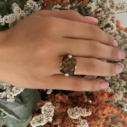 Comprar sortija de oro amarillo de 18kt con piedra central de color café y pavé de diamantes en los brazos. Joyería compro oro Ian'Or. Envío GRATIS.