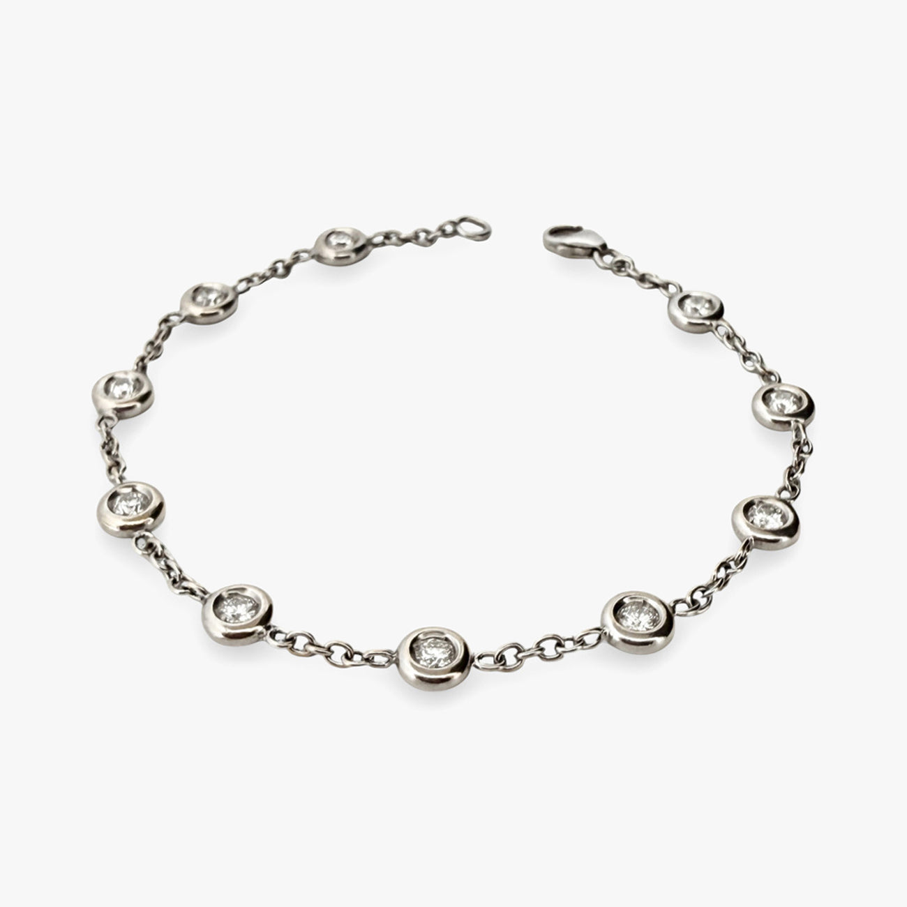 Pulsera de oro blanco de 18kt con cadena forzada y diamantes alternos con engaste chatón. Cierre tipo mosquetón. La pulsera mide 18cm. Envío gratis.