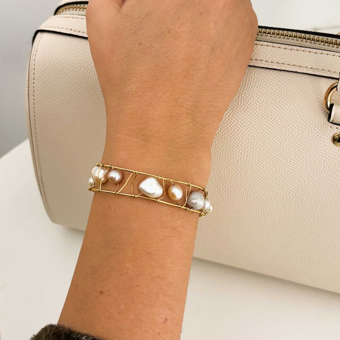 Pulsera original de Tous con perlas de distintos tonos en Oro amarillo de 18kt. La pulsera mide 6,4cm de diámetro y las perlas 12,30mm. Esta pieza ha sido restaurada en nuestro taller de Barcelona. Compro Oro al mejor precio, joyería segunda mano Barcelona, diseño y transformación de joyas.