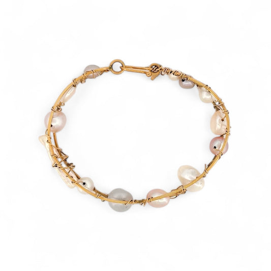 Pulsera original de Tous con perlas de distintos tonos en Oro amarillo de 18kt. La pulsera mide 6,4cm de diámetro y las perlas 12,30mm. Esta pieza ha sido restaurada en nuestro taller de Barcelona. Compro Oro al mejor precio, joyería segunda mano Barcelona, diseño y transformación de joyas.