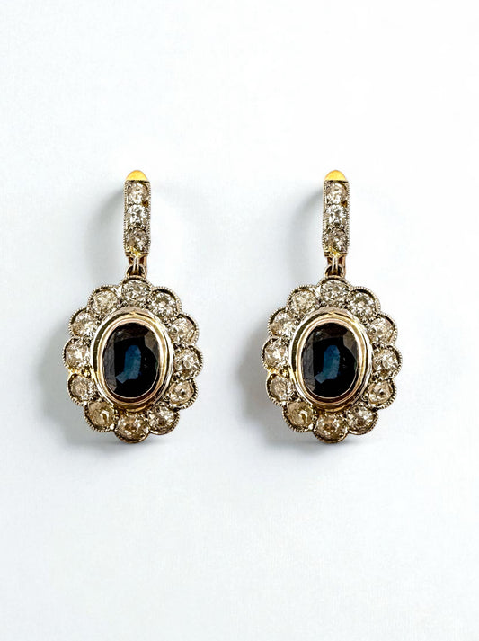 Pendientes vintage de oro amarillo de 18kt  con diamantes talla antigua en platino. Estos maravillosos pendientes antiguos están compuestos por 2 rosetones de platino con engaste en chatón de un zafiro talla oval y orla de 12 diamantes talla antigua cada uno , lo que los convierte en una joya excepcional Cierre catalan