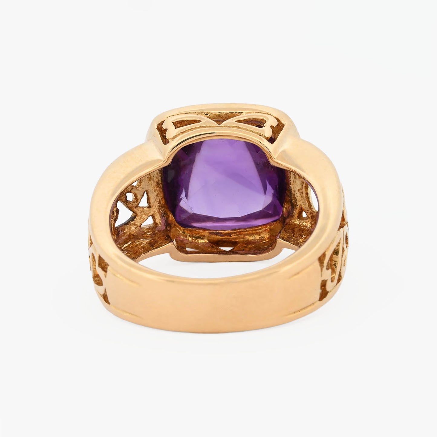 Comprar anillo ancho de oro amarillo de 18kt y amatista cabujon en forma de piramide, montada en un aro semicalado con formas de corazon.