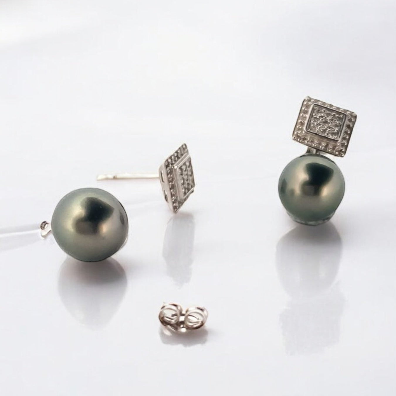 Comprar pendientes tu y yo de oro blanco de 18kt con pavé cuadrado de diamantes talla brillante y perla negra. Estos pendientes tienen la particularidad de poder usarse de dos formas distintas, con perla o sin perla. Cierre a presión. Comprar pendientes segunda mano en barcelona. Comprar oro en Barcelona. Restauración de joyas en Barcelona.