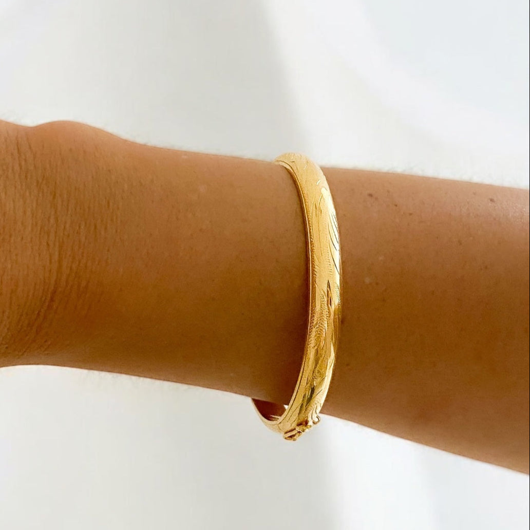 Comprar pulsera esclava con grabado en la parte de fuera y interior liso realizada en oro amarillo de 18kt. Cierre de cajón con un brazo de seguridad. Ian'Or.