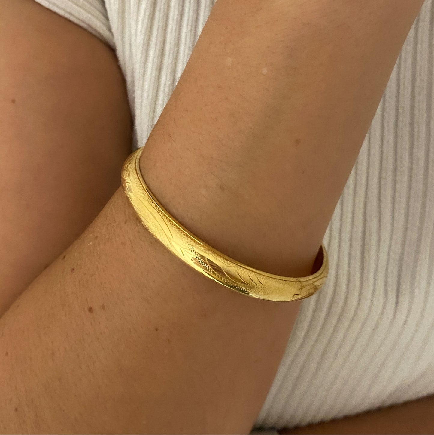 Comprar pulsera esclava con grabado en la parte de fuera y interior liso realizada en oro amarillo de 18kt. Cierre de cajón con un brazo de seguridad. Ian'Or.