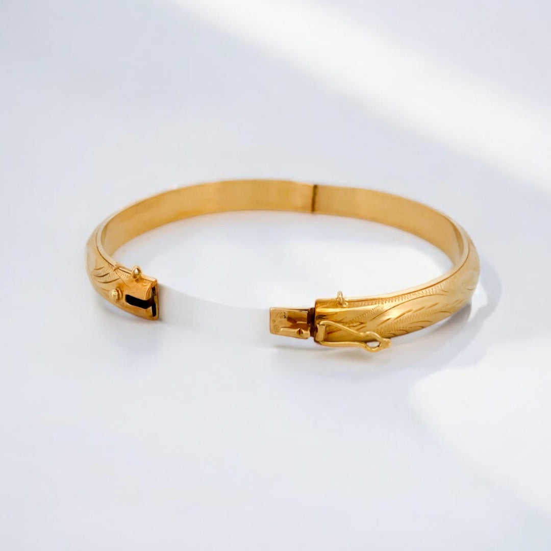 Comprar pulsera esclava con grabado en la parte de fuera y interior liso realizada en oro amarillo de 18kt. Cierre de cajón con un brazo de seguridad. Ian'Or.
