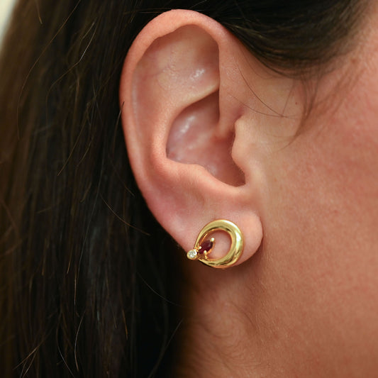 Pendientes de silueta curva entrelazada con cierre Omega de oro amarillo 18kt con rubí central y diamantes. Joyas de segunda mano restauradas y envío gratis.
