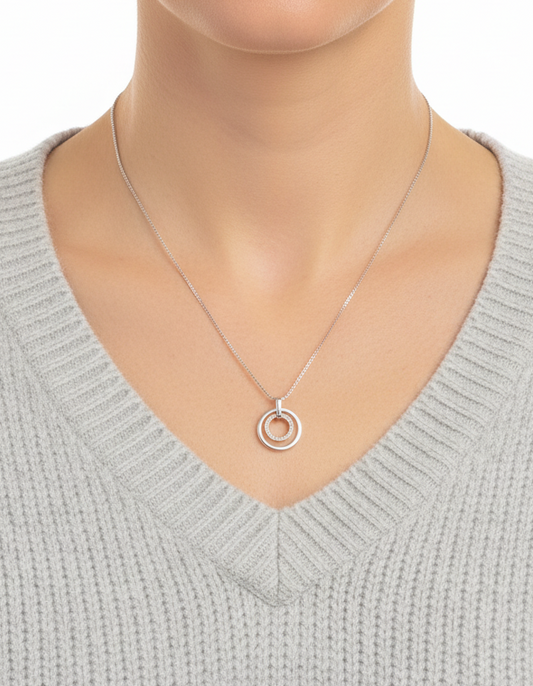 Comprar colgante medalla de oro blanco con dos circulos, uno de ellos lleva 23 diamantes.