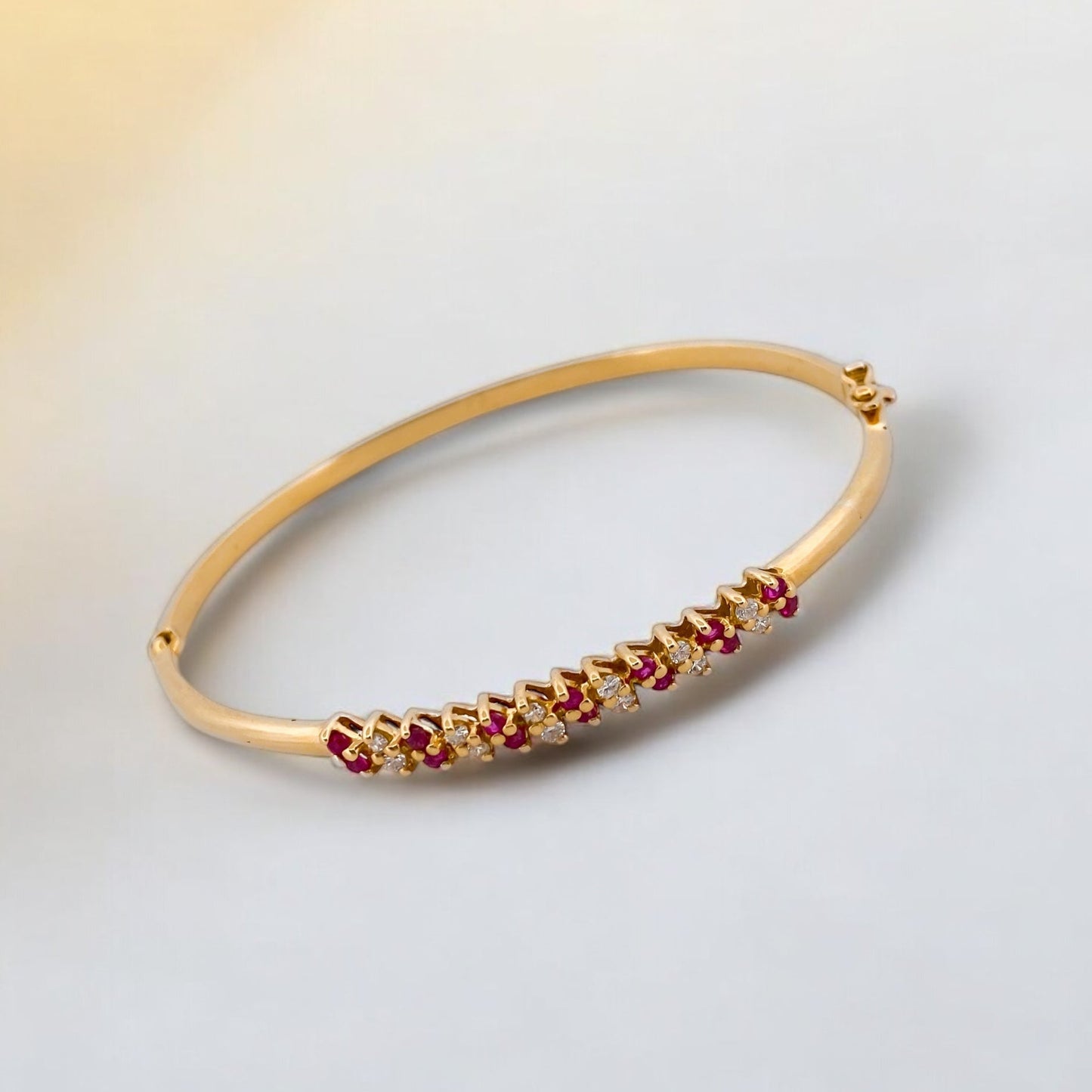 Comprar pulsera esclava realizada en oro amarillo de 18kt con diamantes y rubíes. Cierre de cajón con un brazo de seguridad. Joyas restauradas. Joyería Ian'Or.