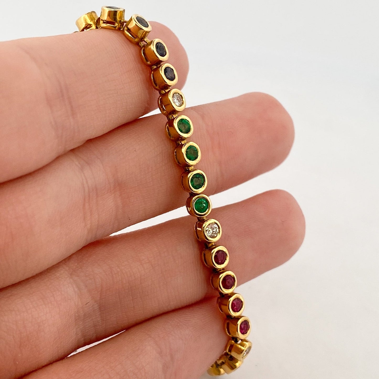 Pulsera semirígida de oro de 18kt con 3 rubíes, 3 esmeraldas y 30 zafiros azules talla princesa. Joyería Ian'Or. Joyas segunda vida. Envío GRATIS.