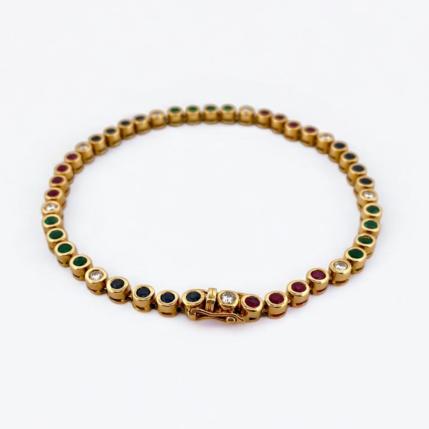 Pulsera semirígida de oro de 18kt con 3 rubíes, 3 esmeraldas y 30 zafiros azules talla princesa. Joyería Ian'Or. Joyas segunda vida. Envío GRATIS.