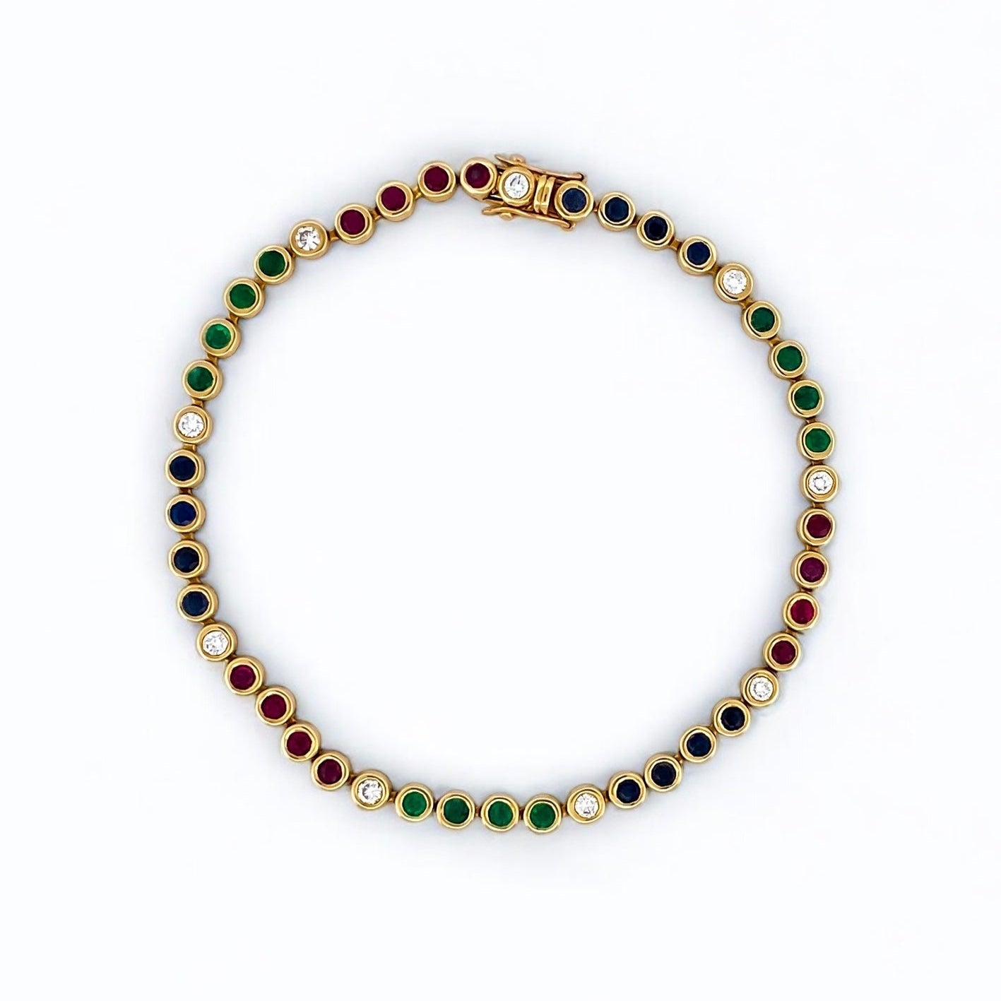 Pulsera semirígida de oro de 18kt con 3 rubíes, 3 esmeraldas y 30 zafiros azules talla princesa. Joyería Ian'Or. Joyas segunda vida. Envío GRATIS.