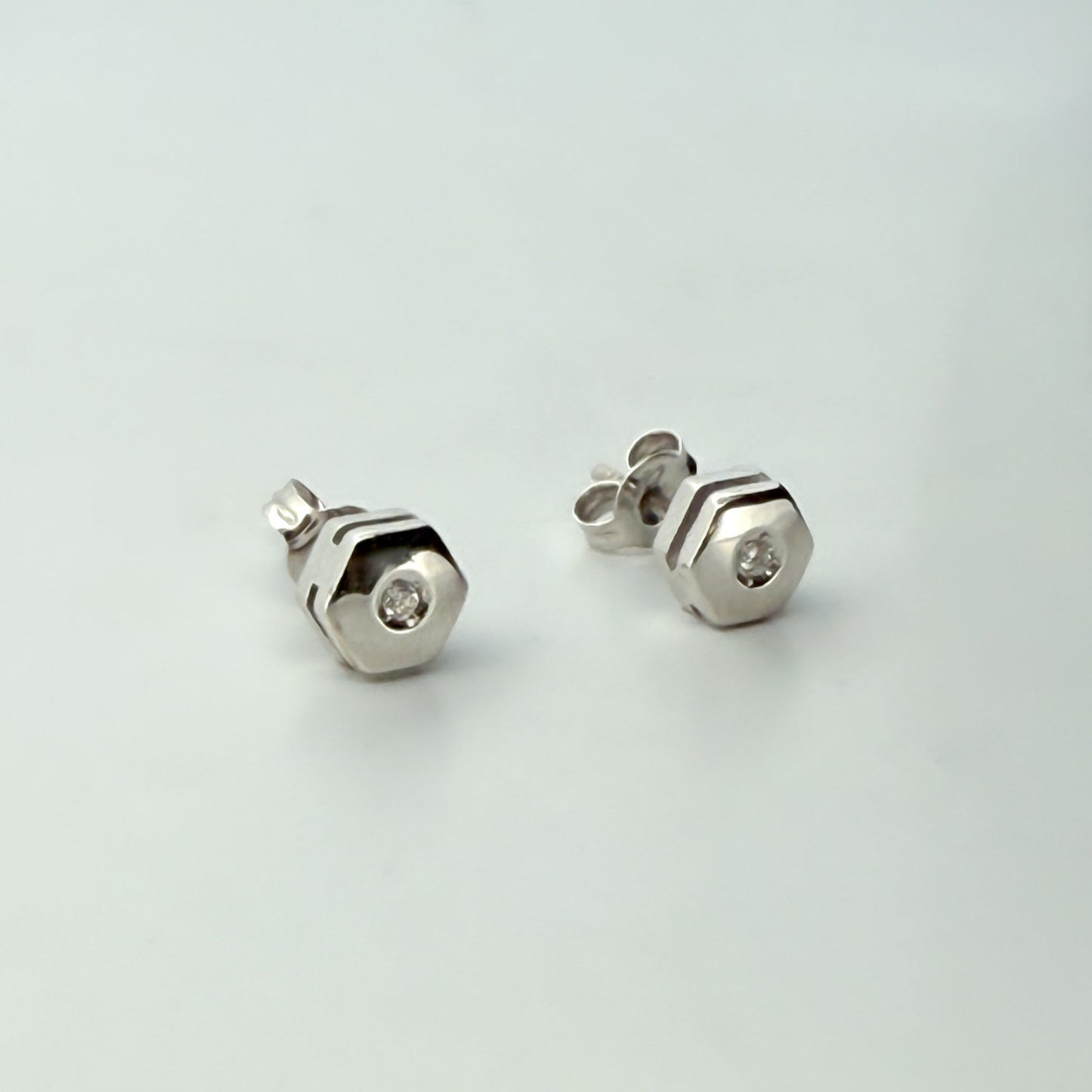 Comprar pendiente en forma de hexágono realizados en oro blanco de 18kt y un diamante talla brillante en cada pendiente. Envío gratis. Joyería Ian'Or.