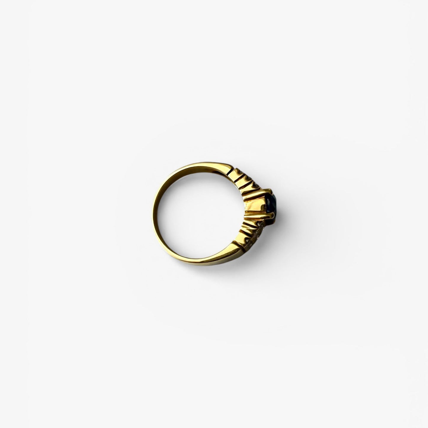 Comprar anillo realizado en oro amarillo de 18kt con un zafiro central engastado en 4 grapas y 9 diamantes cada lado. Joyas de segunda mano Barcelona. Envío gratis.