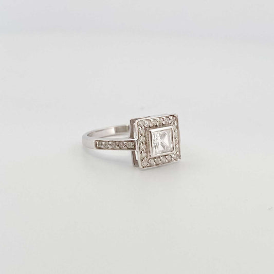 Anillo realizado en oro blanco de 18t con diamante central talla princesa y orla de 30 diamantes de 0,01ct cada uno. Oro y venta de joyas restauradas, dónde comprar y vende oro y joyas al mejor precio en Barcelona. Anillos de oro baratos en Barcelona.