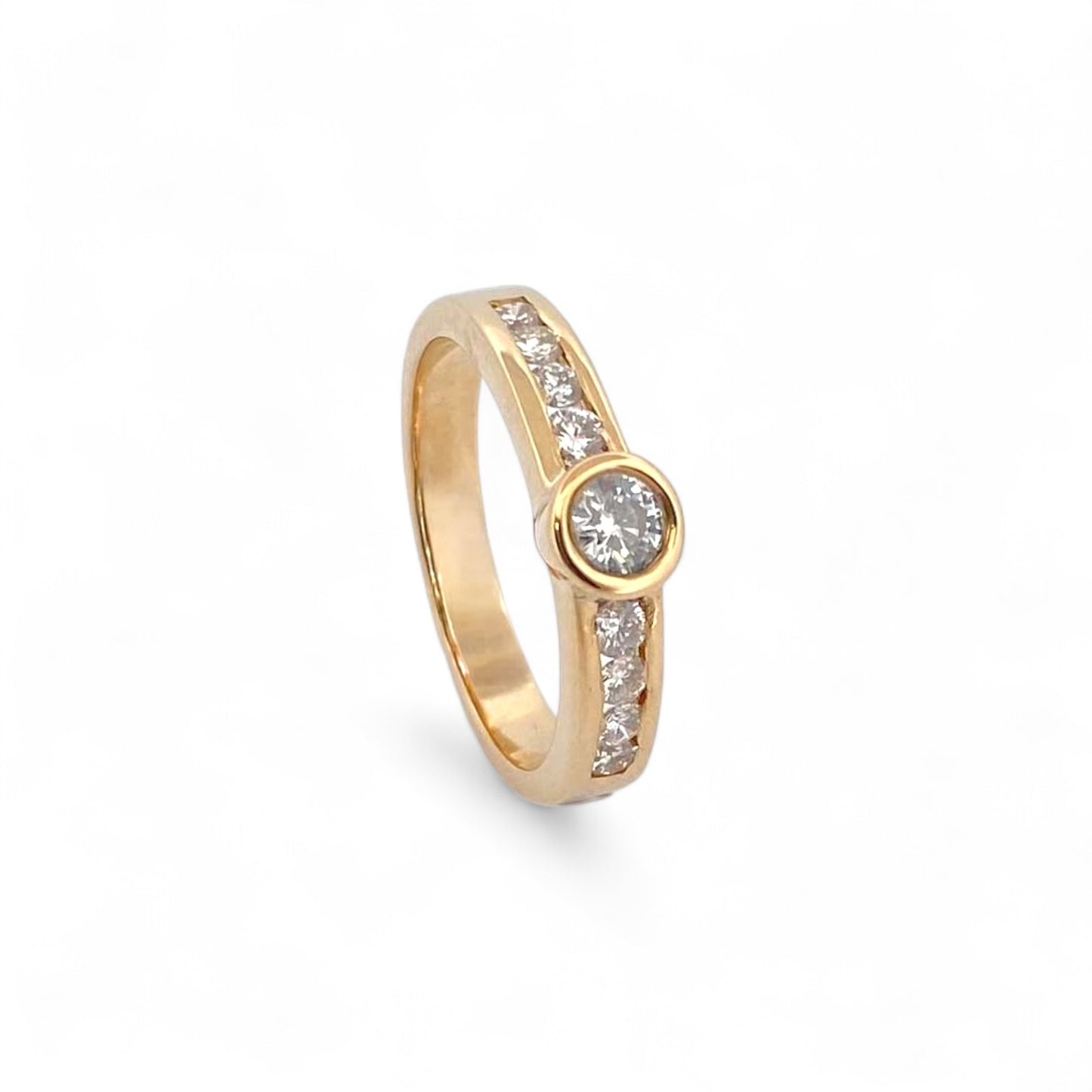 Anillo realizado en oro amarillo de 18kt con brillante central de 0,10ct y 2 carriles en cada brazo con 4 diamantes de 0,04ct cada uno. Joyas de segunda mano restauradas baratas en Barcelona, mejor precio de compro oro y venta de joyas donde conseguir el mejor precio.