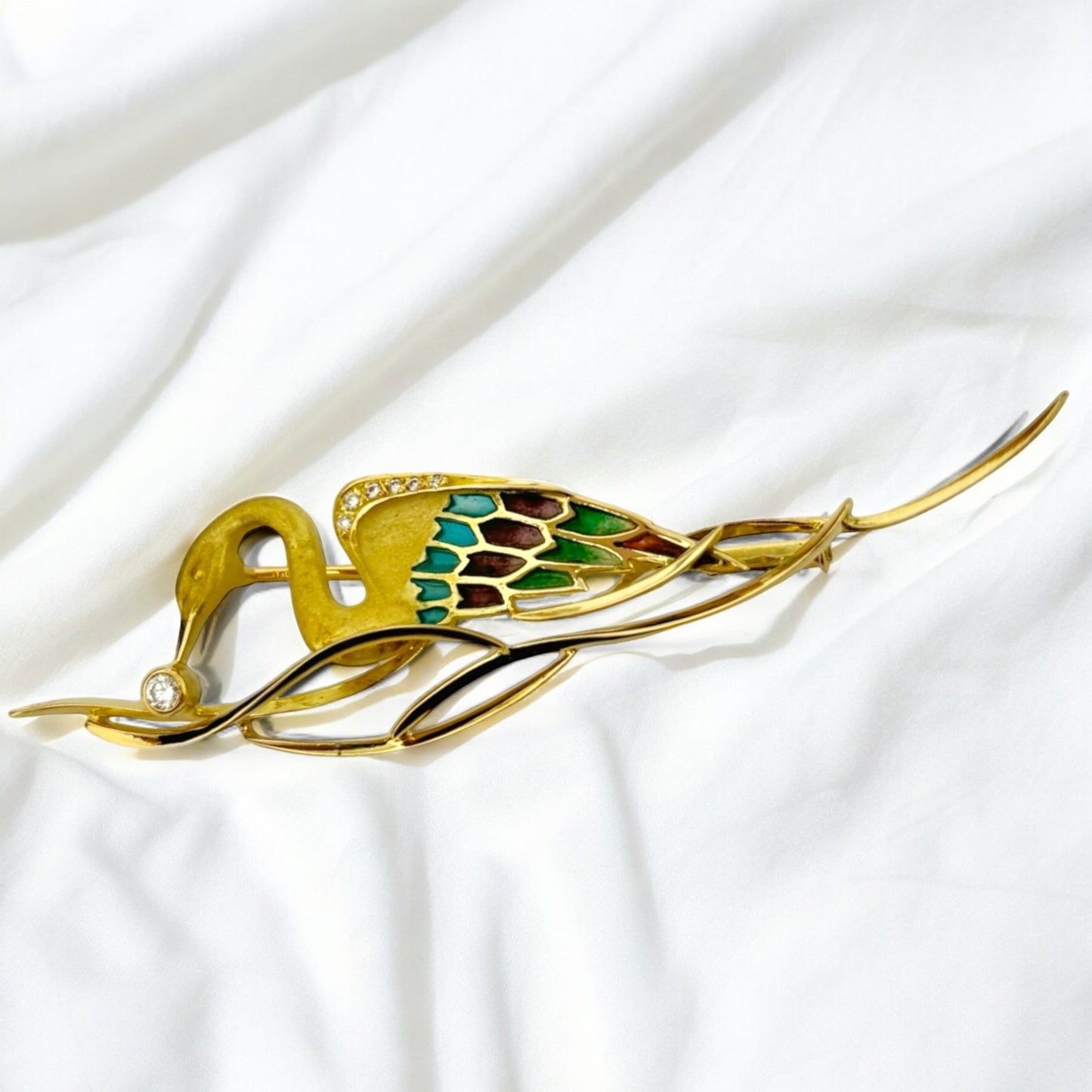 Broche realizado en oro amarillo de 18kt con un cisne que sujeta un diamante talla brillante. Esta pieza stá inspirada en las joyas del artista Lluis Masriera, que revolucionó el sector de la joyería Art Noveau en Europa con sus piezas con motivos de la naturaleza , fantasía y color.Joyas antiguas y vintage en Barcelona, compro oro y joyas al mejor precio. Joyería Compro Oro Barcelona, el mejor precio por tu oro y por joyas de segunda mano