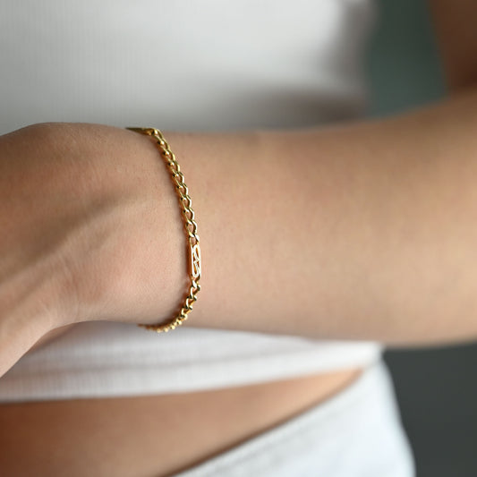 Compra Pulsera de eslabones combinados de oro amarillo de 18Kt y cierre tipo mosquetón. Con un diseño que destaca por su estructura geométrica intermitente, que combina tramos de eslabón tradicional con placas alargadas caladas, ofreciendo una pieza ligera, resistente y de estética equilibrada.