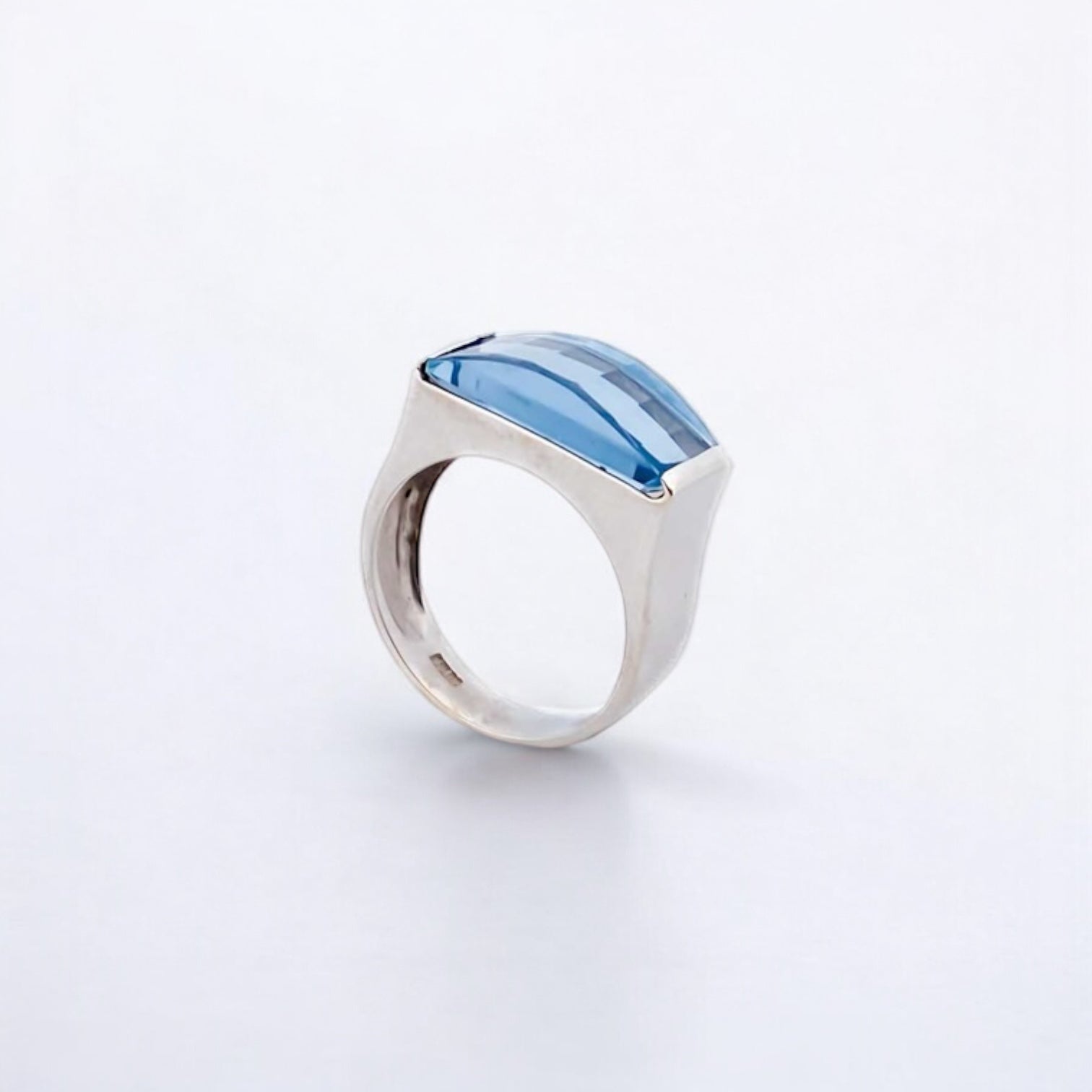 Anillo ancho de oro blanco de 18kt con piedra azul central. Joyería compro oro, dónde comprar y vender joyas al mejor precio en Barcelona. Joyas baratas.