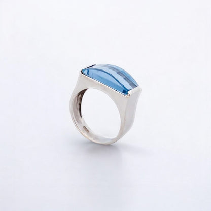 Anillo ancho de oro blanco de 18kt con piedra azul central. Joyería compro oro, dónde comprar y vender joyas al mejor precio en Barcelona. Joyas baratas.