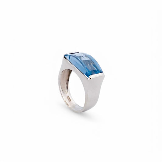 Anillo ancho de oro blanco de 18kt con piedra azul central. Joyería compro oro, dónde comprar y vender joyas al mejor precio en Barcelona. Joyas baratas.