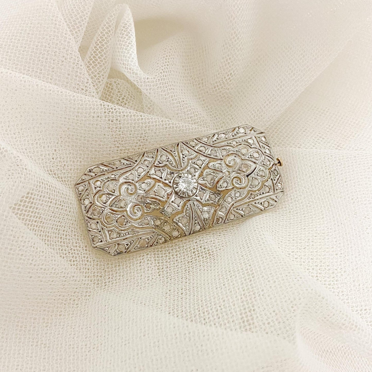 Espectacular broche vintage estilo Art Decó de los años 20 realizado en Oro Amarillo de 18kt y pieza superior de platino con diamante central y decorado con 70 diamantes de talla antigua. Una pieza muy especial para Novias dándoles diferentes uso: para decorar un peinado de novia, en el vestido o en la cintura a modo de cierre de cinturón, cierre del chal o velo o incluso en el ramo. Joyas para novia vintage de lujo.