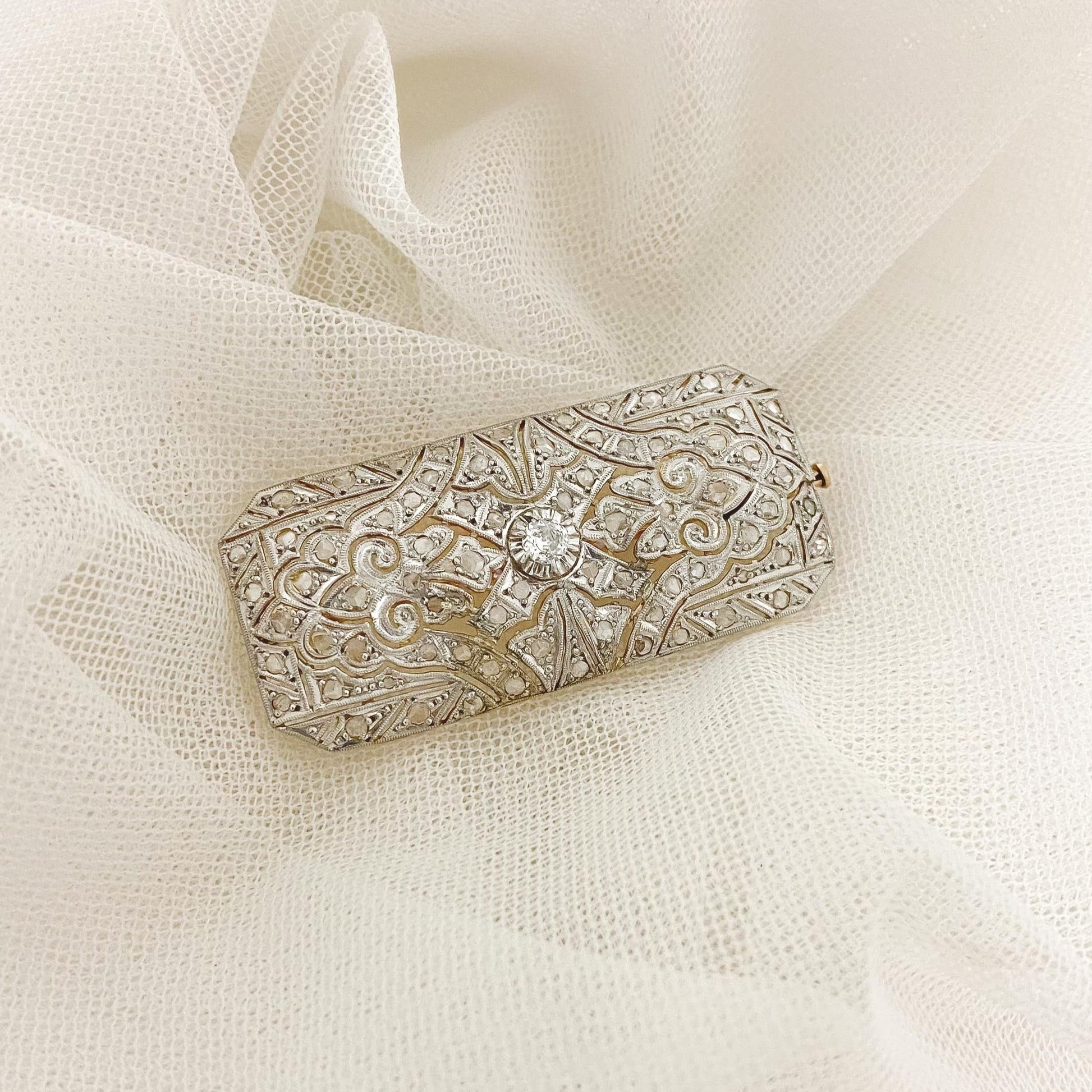 Espectacular broche vintage estilo Art Decó de los años 20 realizado en Oro Amarillo de 18kt y pieza superior de platino con diamante central y decorado con 70 diamantes de talla antigua. Una pieza muy especial para Novias dándoles diferentes uso: para decorar un peinado de novia, en el vestido o en la cintura a modo de cierre de cinturón, cierre del chal o velo o incluso en el ramo. Joyas para novia vintage de lujo.
