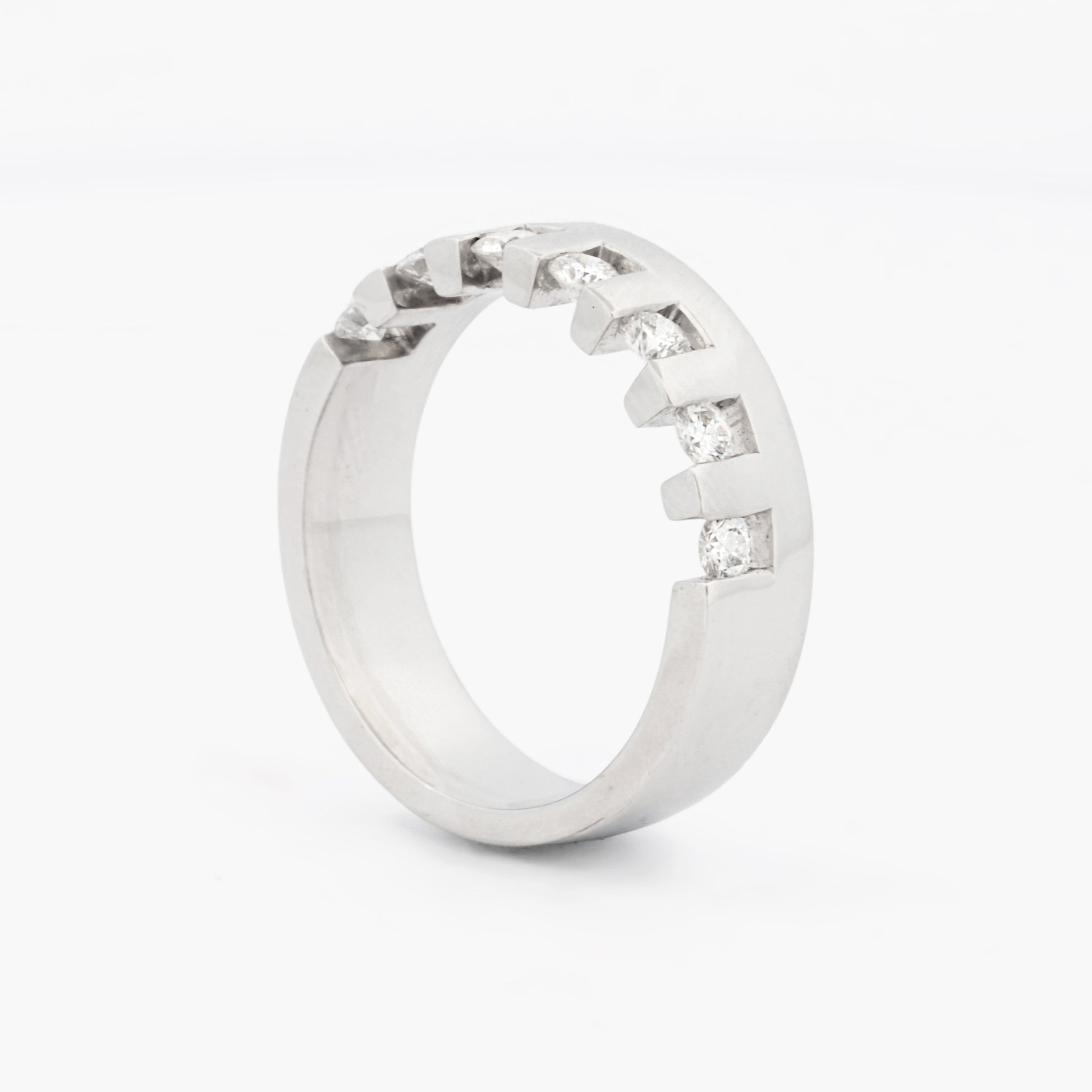 Media alianza de oro blanco de 18kt y 7 diamantes talla brillante engarzados individualmente en un carril privativo por diamante. Joyas baratas Barcelona.