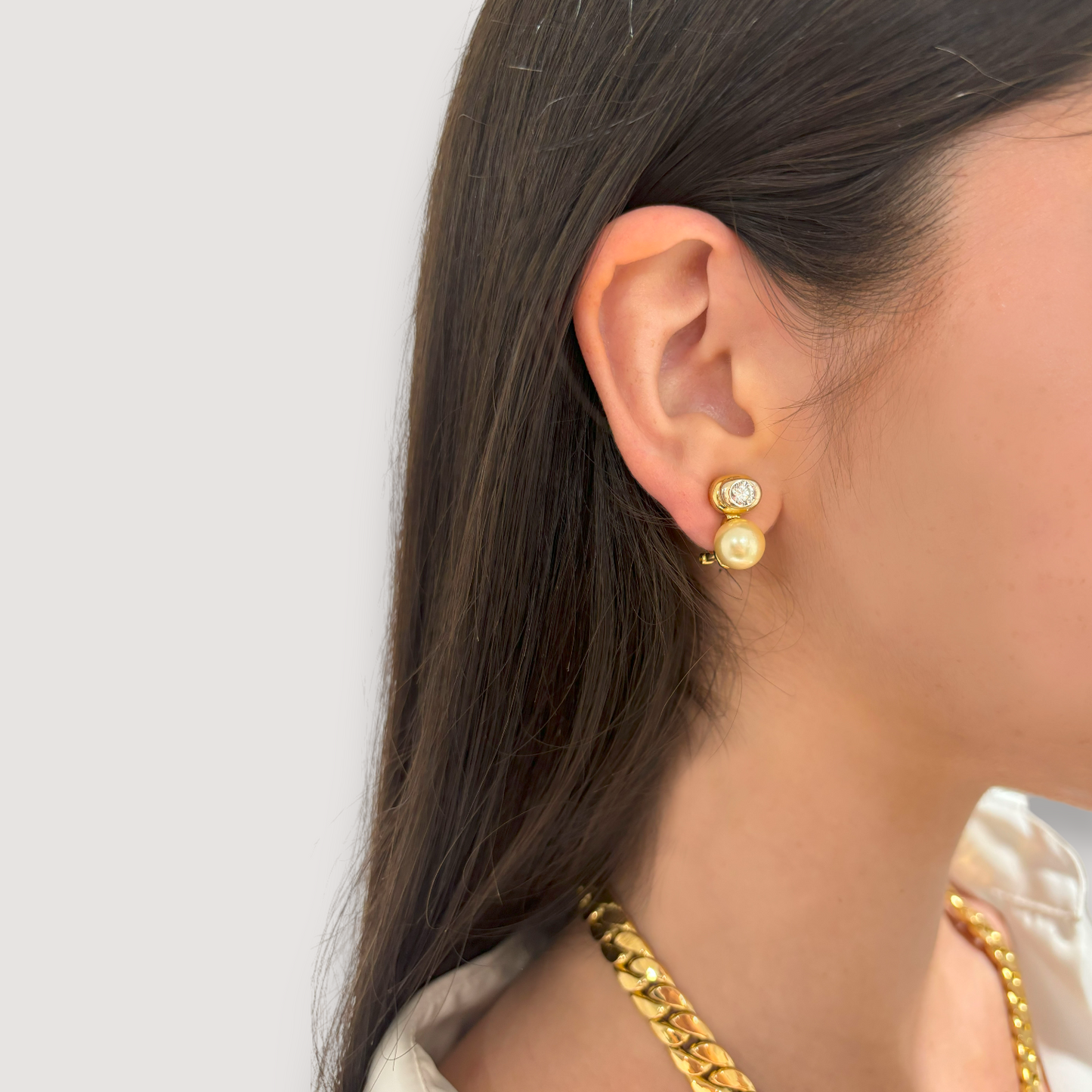 Pendientes tu y yo de oro amarillo de 18kt de la firma Vasari con 2 diamantes de __ cada uno y perla cultivada de 6,30mm cada una. Estos preciosos pendientes disponen de cierre tipo Omega Joyería Barcelona, segunda mano, restauración y creación de joyas, compro oro Barcelona. Joyas Vasari y joyería de lujo.