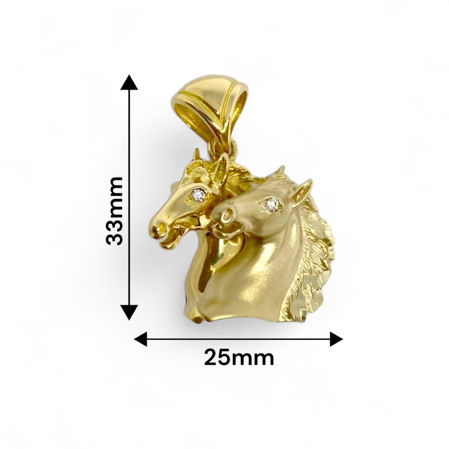 Colgante de Oro Amarillo de 18kt con 2 cabezas de caballo mate y brillante. Detalle de circonitas en los ojos.  Medida: 33mm de alto (con la balia) y 25mm ancho. Peso: 10,67g Material: Oro blanco de 18 kt