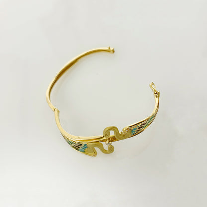 Espectacular pulsera de oro amarillo de 18kt tipo esclava con 2 cisnes que sujetan un diamante talla brillante. Esta esclava está inspirada en las joyas del artista Lluis Masriera, que revolucionó el sector de la joyería Art Noveau en Europa con sus piezas con motivos de la naturaleza , fantasía y color. Dispone de cierre tipo cajón y cierre de seguridad. Joyas antiguas y vintage en Barcelona, compro oro y joyas al mejor precio. 