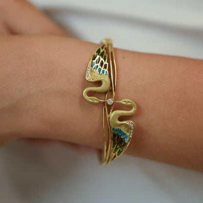 Espectacular pulsera de oro amarillo de 18kt tipo esclava con 2 cisnes que sujetan un diamante talla brillante. Joyas antiguas y vintage en Barcelona.