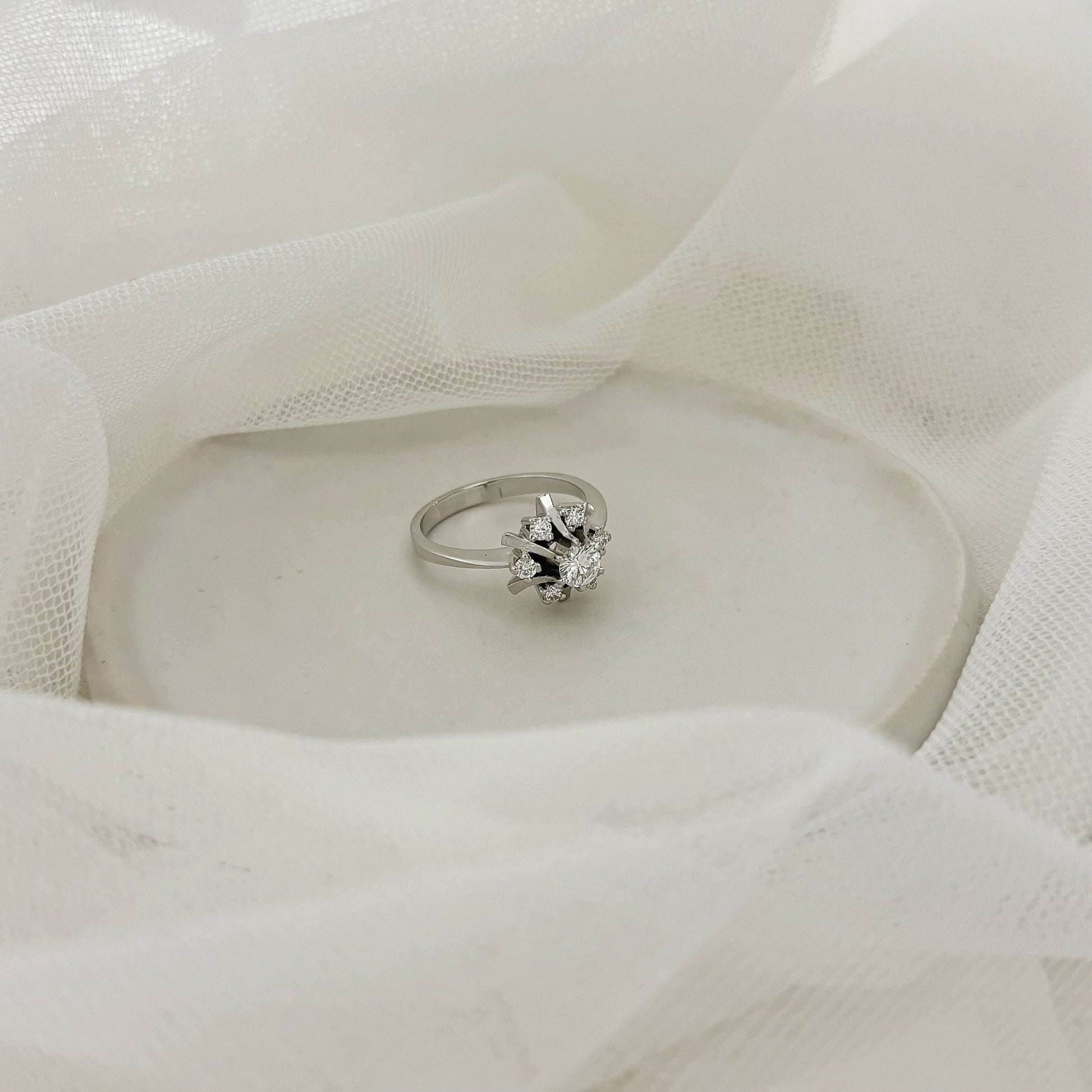Anillo antiguo realizado en Oro blanco de 185kt con rosetón de diamantes. Diamante central  y rosetón de 6 diamantes. Joyería de segunda mano y vintage  en Barcelona y compro oro, donde comprar y vender oro al mejor precio en Barcelona. Venta de joyas con diamantes de la mejor calidad al mejor precio. Joyas para novias