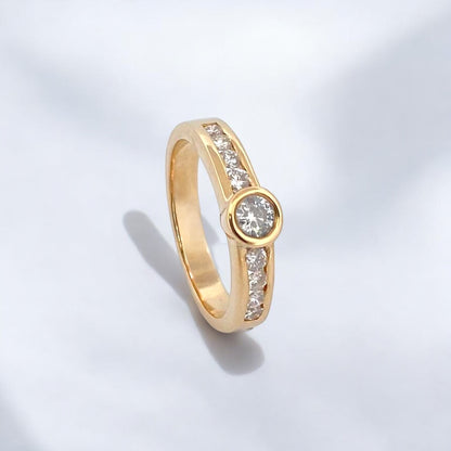 Anillo realizado en oro amarillo de 18kt con brillante central de 0,10ct y 2 carriles en cada brazo con 4 diamantes de 0,04ct cada uno. Joyas  de segunda mano restauradas baratas en Barcelona, mejor precio de compro oro y venta de joyas donde conseguir el mejor precio.
