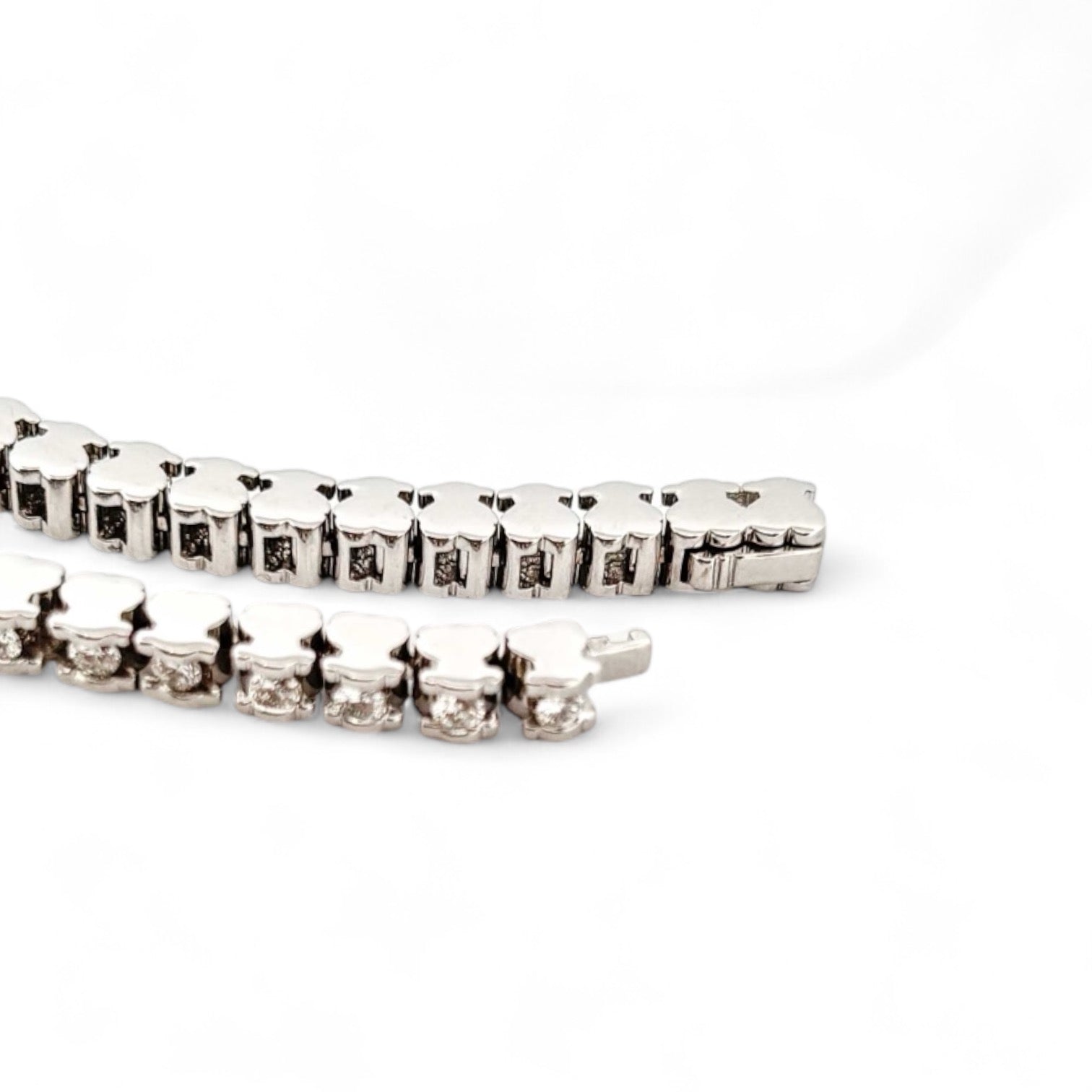 Pulsera Riviere de la firma TOUS realizada en oro blanco de 18kt con 46 diamantes talla brillante de 0,05 ct cada uno con engaste en tensión con detalles del icónico osito. Una preciosa joya con más de 2 quilates de diamantes. La pulsera mide 19cm y dispone de cierre de cajón
Joyas de segunda mano de firma. Joyas Tous restauradas al mejor precio, donde encontrar joyas baratas